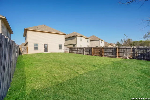 a view of a house with a big yard and large trees