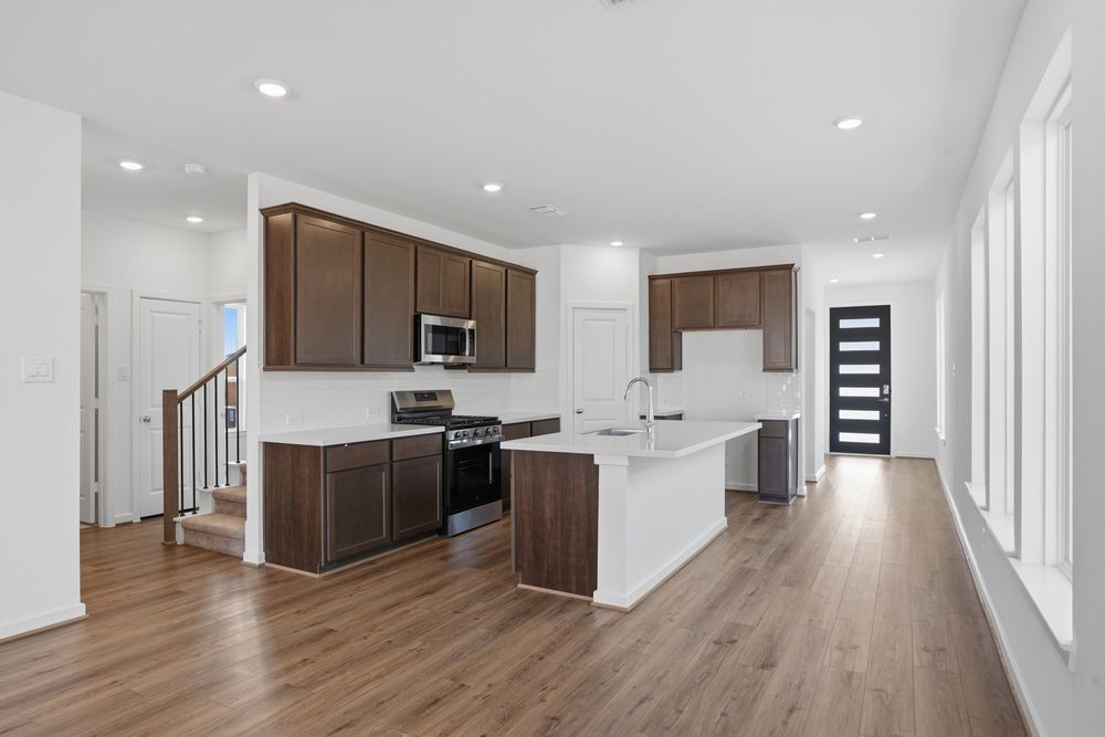 22122 Rangemore Drive Cypress, TX 77433 - Photo 2 of 28 a large kitchen with stainless steel appliances kitchen island granite countertop a stove top oven a sink a dining table and chairs