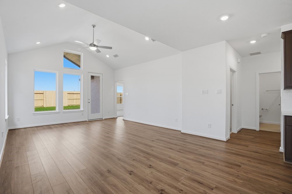 22122 Rangemore Drive Cypress, TX 77433 - Photo 4 of 28 an empty room with wooden floor ceiling fan and windows