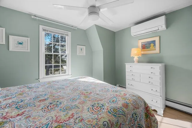 a bedroom with a bed and a dresser next to a window