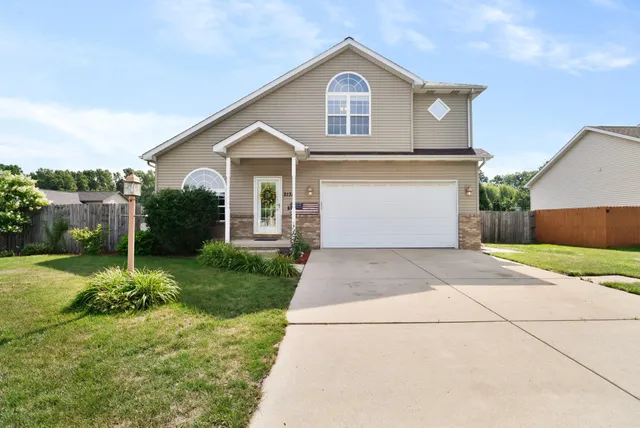 a front view of a house with a yard and garage