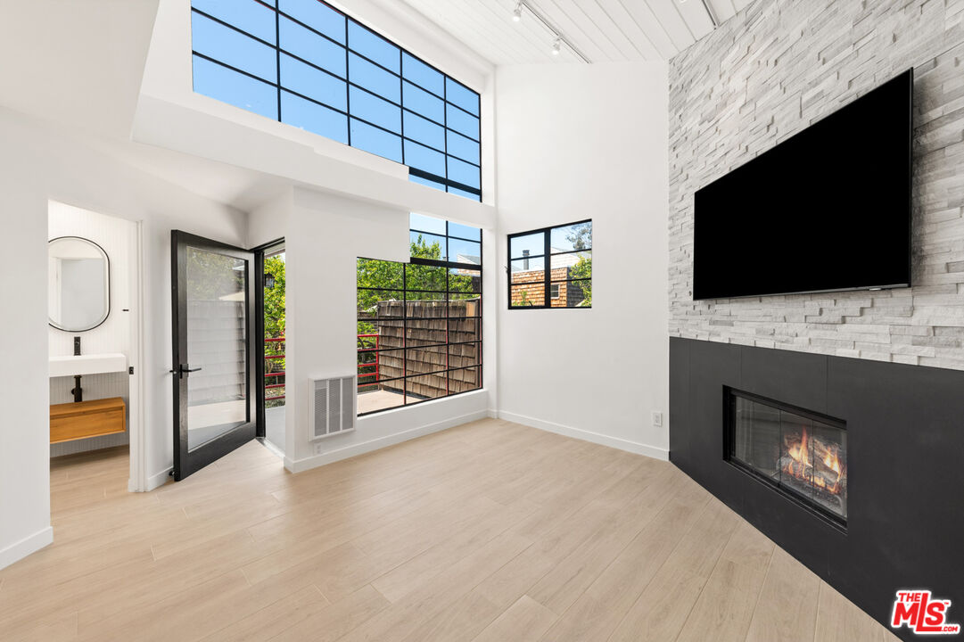 a view of an empty room with a fireplace and a window