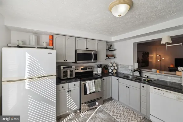 a kitchen with stainless steel appliances kitchen island granite countertop a sink and cabinets