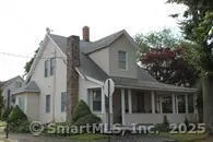 a view of a white house next to a yard