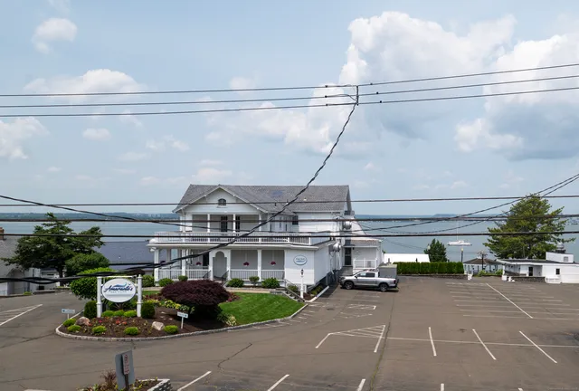 a view of a building with a garden and parking space