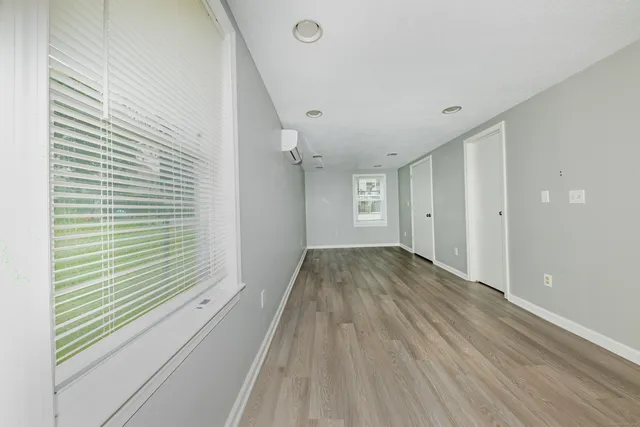 a view of a room with wooden floor and a window