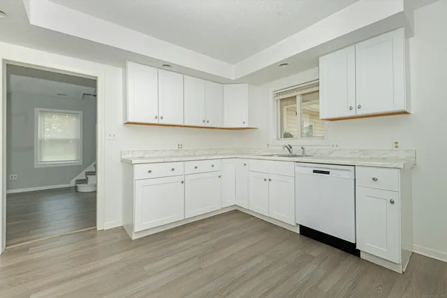 a kitchen with granite countertop white cabinets and sink