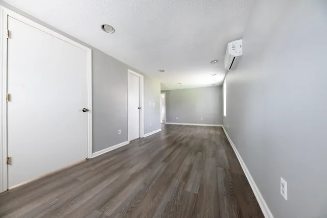 a view of an empty room with wooden floor