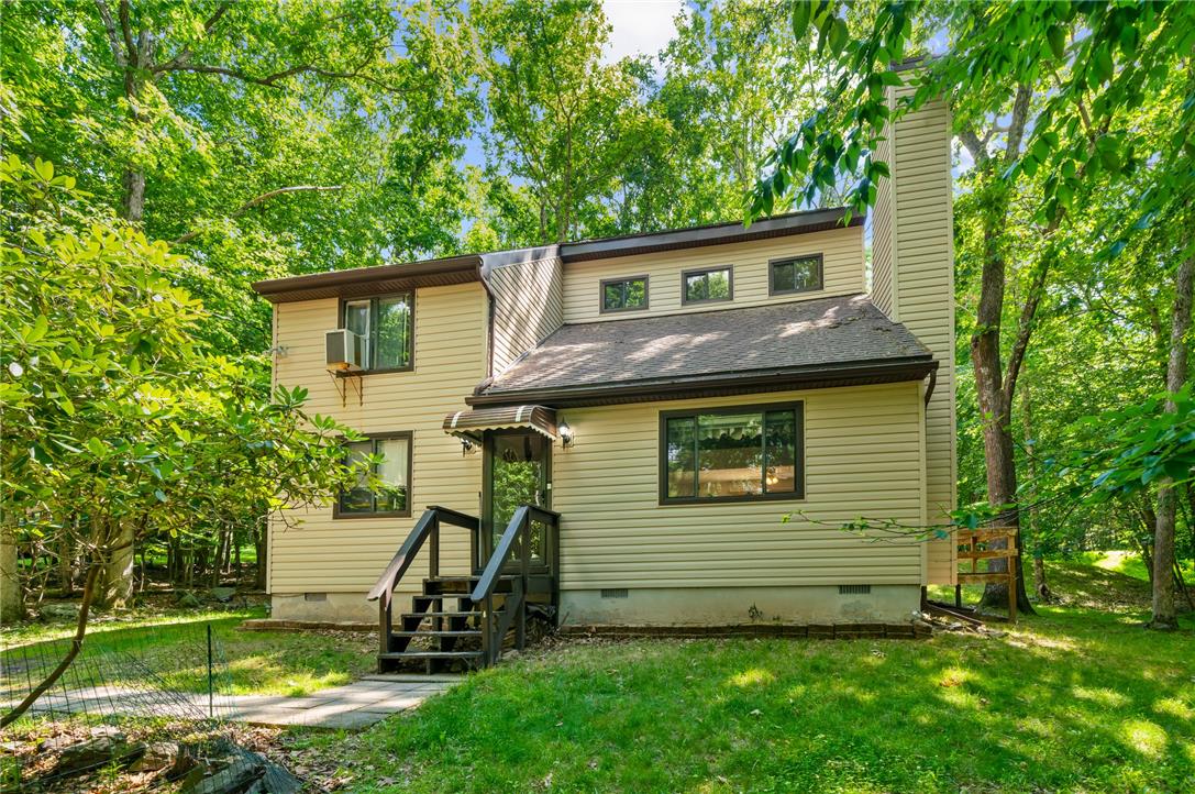 A harmonious blend of siding and shingles offers a quiet, tree-framed residence.