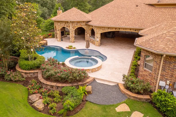 a patio with a table and chairs and potted plants