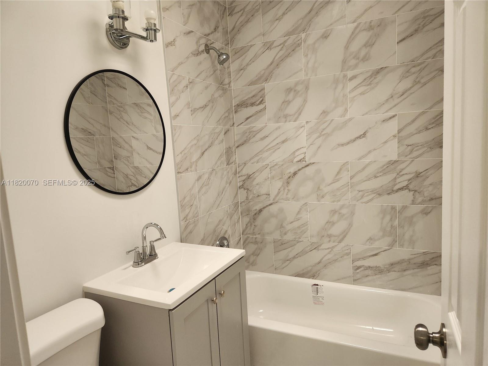 1239 Marseille Drive, Unit 4 Miami Beach, FL 33141 - Photo 11 of 15 a bathroom with a sink and a mirror