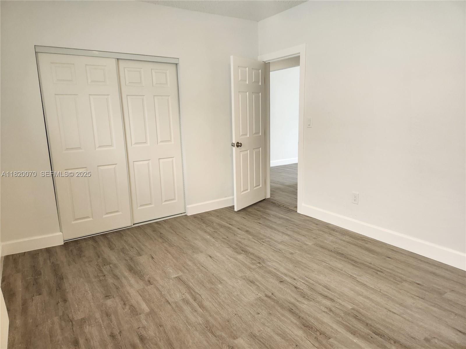 1239 Marseille Drive, Unit 4 Miami Beach, FL 33141 - Photo 12 of 15 a view of an empty room with wooden floor