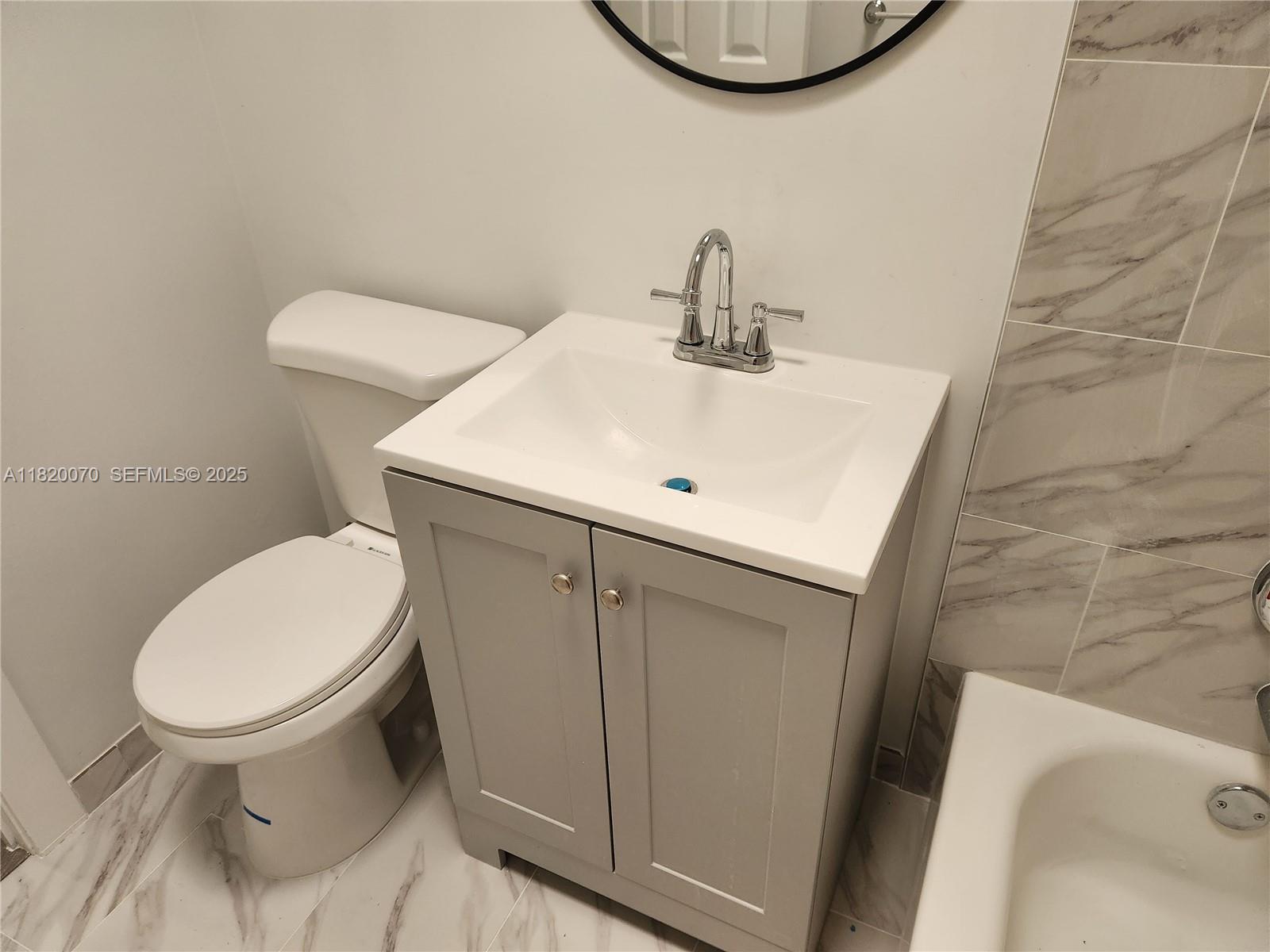 1239 Marseille Drive, Unit 4 Miami Beach, FL 33141 - Photo 10 of 15 a bathroom with a sink a toilet and a mirror