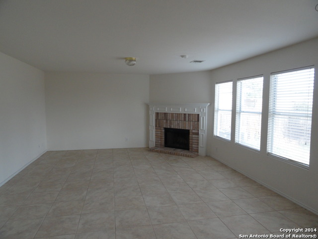8026 Rio NIEBLA San Antonio, TX 78249 - Photo 5 of 15 an empty room with fireplace and windows