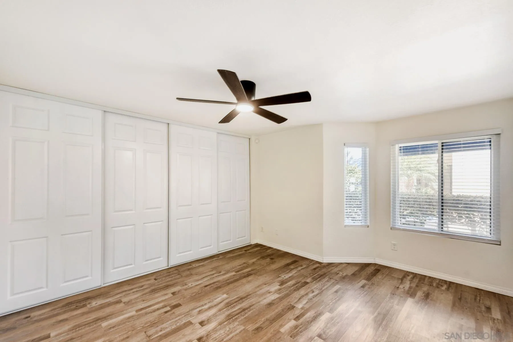8308 Regents Road, Unit 1H San Diego, CA 92122 - Photo 18 of 23 a view of empty room with wooden floor and ceiling fan