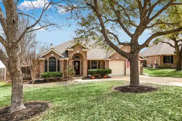 a front view of a house with yard and tree s