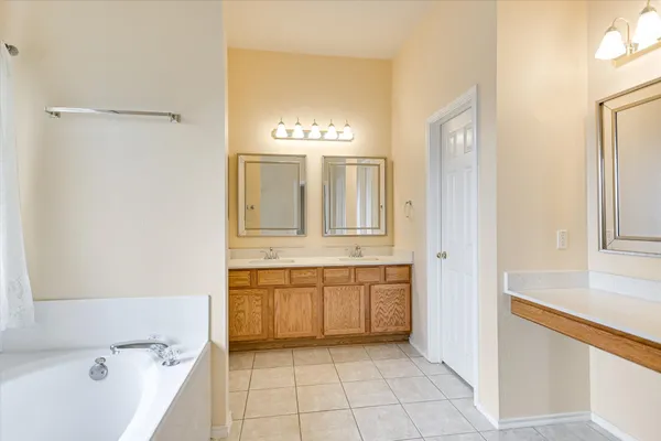 a bathroom with a tub sink and mirror
