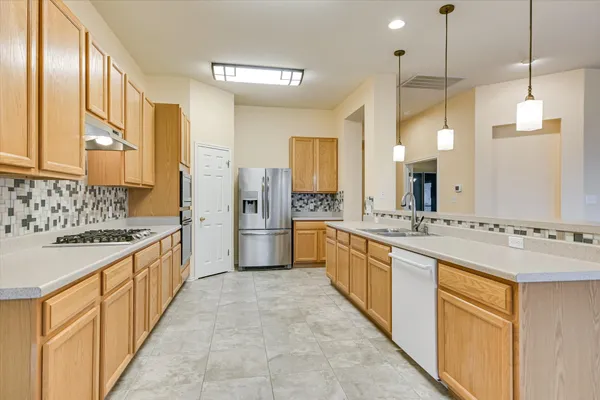 a large kitchen with stainless steel appliances granite countertop a sink and cabinets with wooden floor