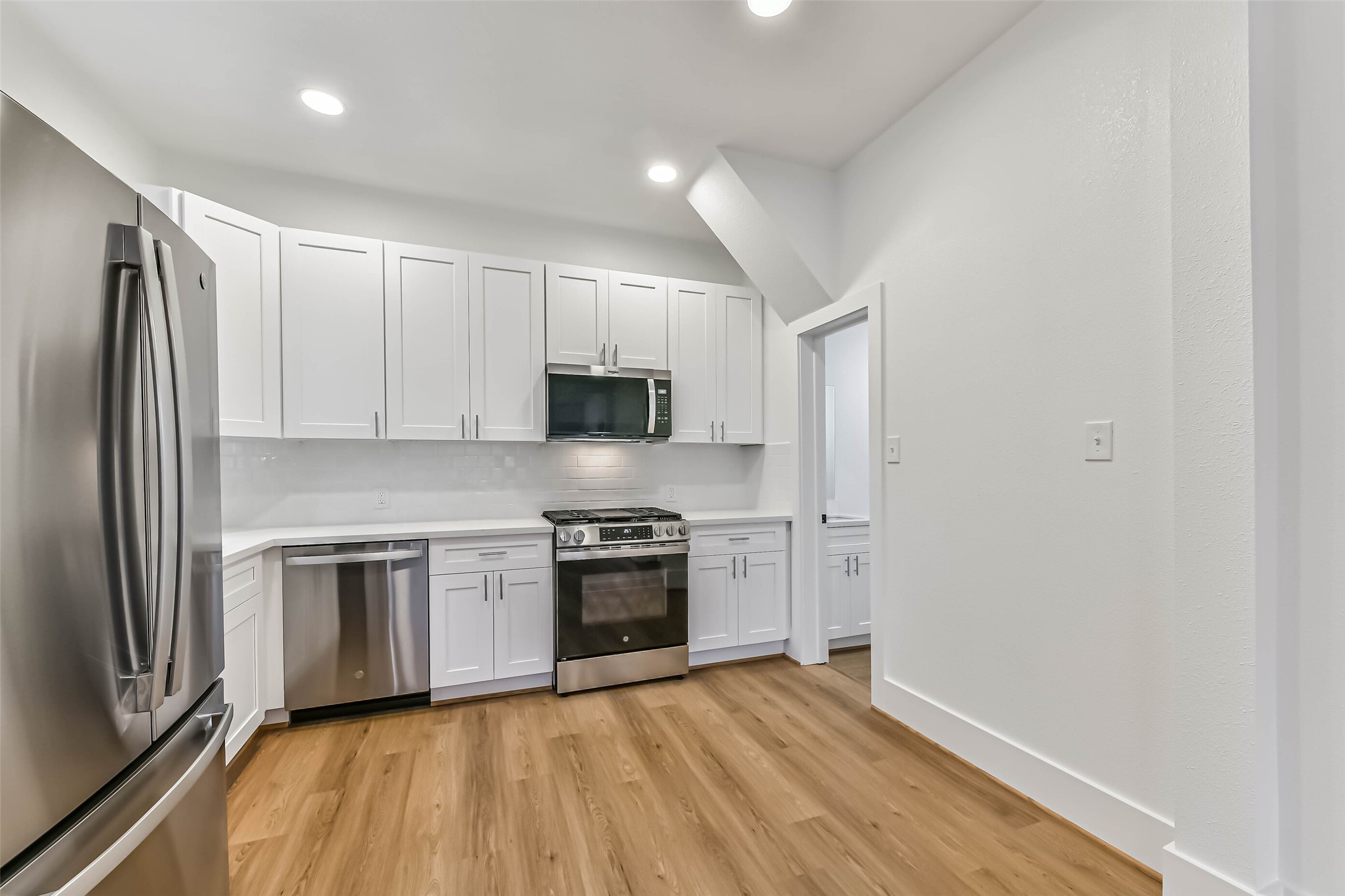 1616 38th Street Galveston, TX 77550 - Photo 14 of 26 a kitchen with stainless steel appliances granite countertop a stove a sink and a refrigerator