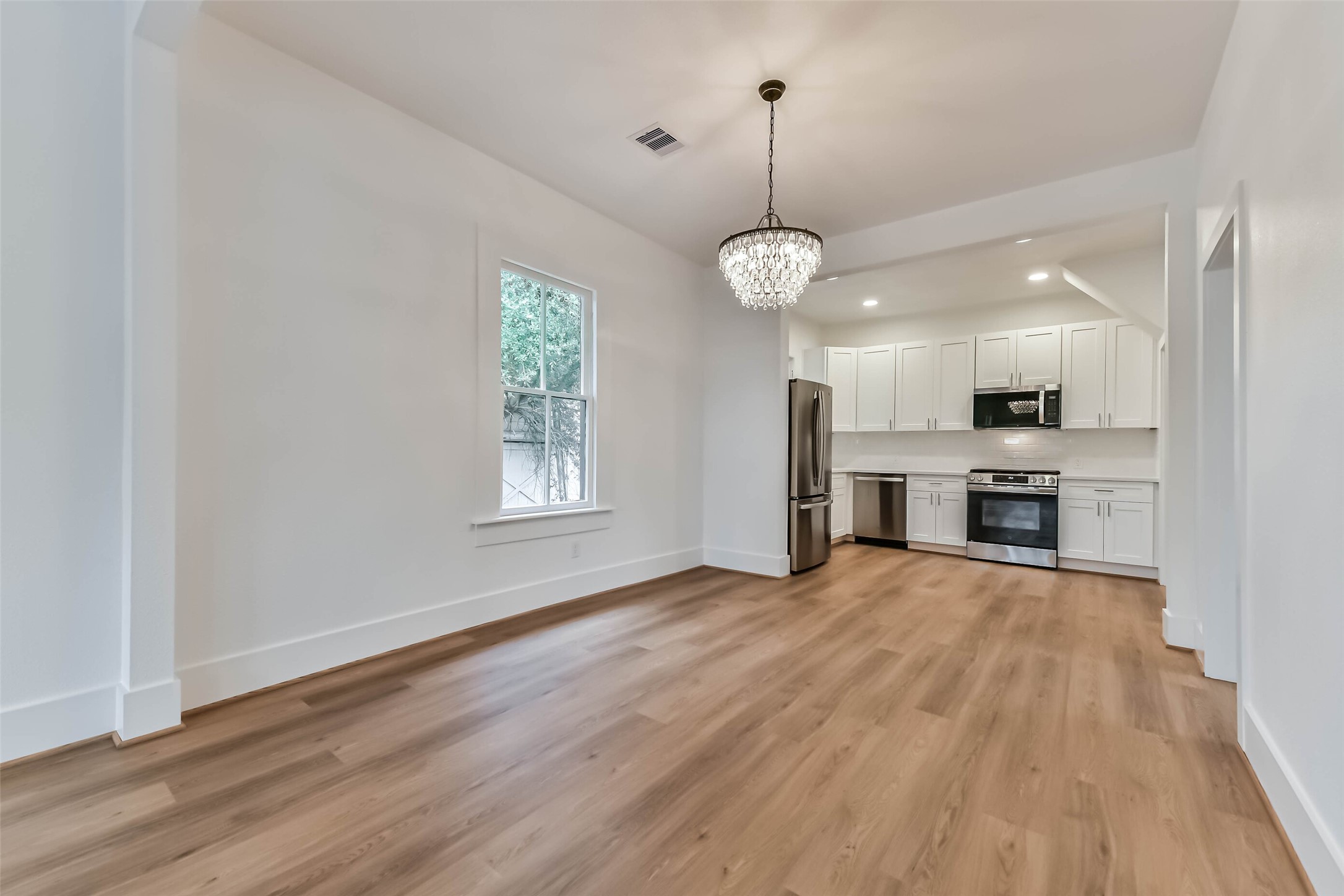 1616 38th Street Galveston, TX 77550 - Photo 9 of 26 a view of empty room with wooden floor and kitchen view
