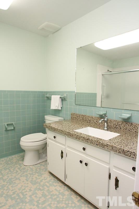 3208 Caldwell Drive Raleigh, NC 27607 - Photo 10 of 22 a bathroom with a granite countertop sink a toilet and a mirror
