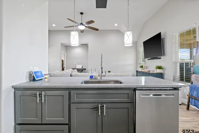 a kitchen with a sink dishwasher a stove a refrigerator with island and cabinets