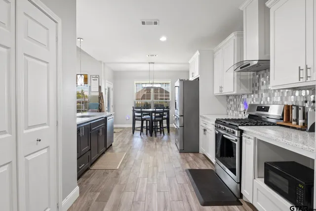 a kitchen with stainless steel appliances granite countertop a stove and a refrigerator