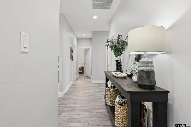 a view of a hallway with furniture and wooden floor