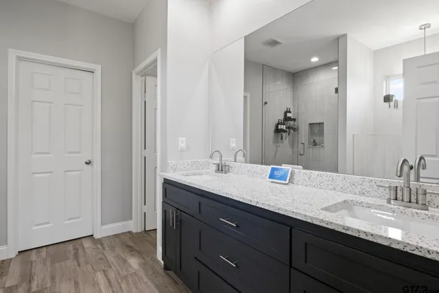a bathroom with a granite countertop sink double and mirror