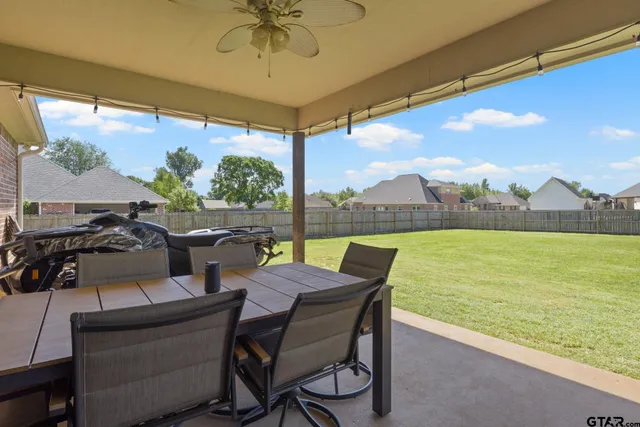 a view of yard from deck with patio