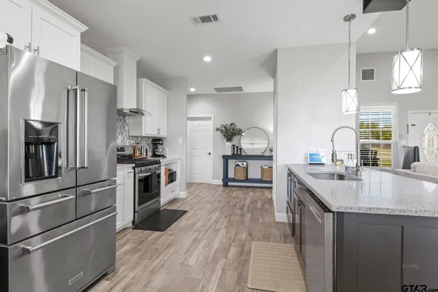 a kitchen with kitchen island granite countertop a sink appliances cabinets and counter space