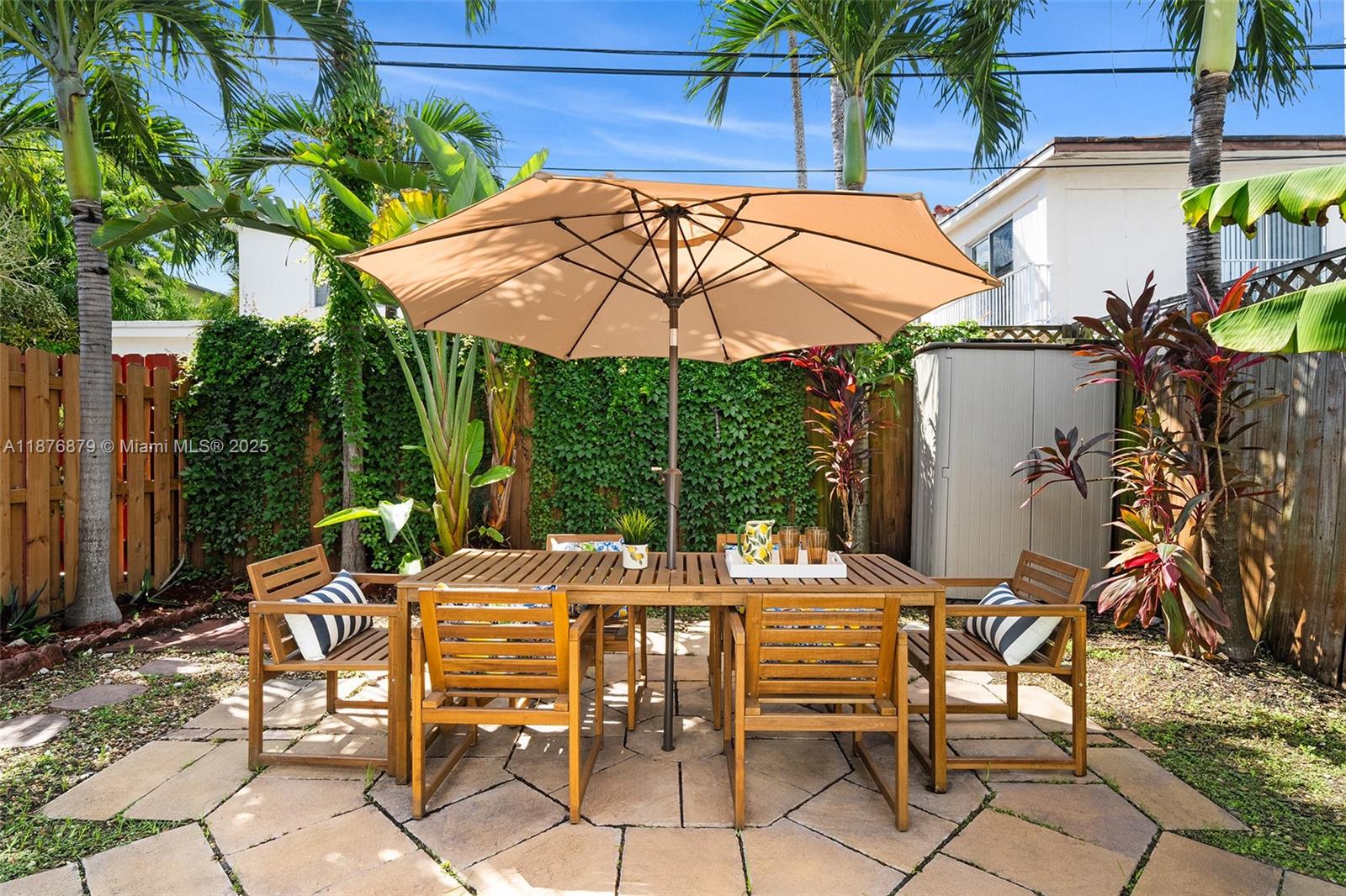 642 86th Street Miami Beach, FL 33141 - Photo 14 of 48 a view of a patio with table and chairs under an umbrella