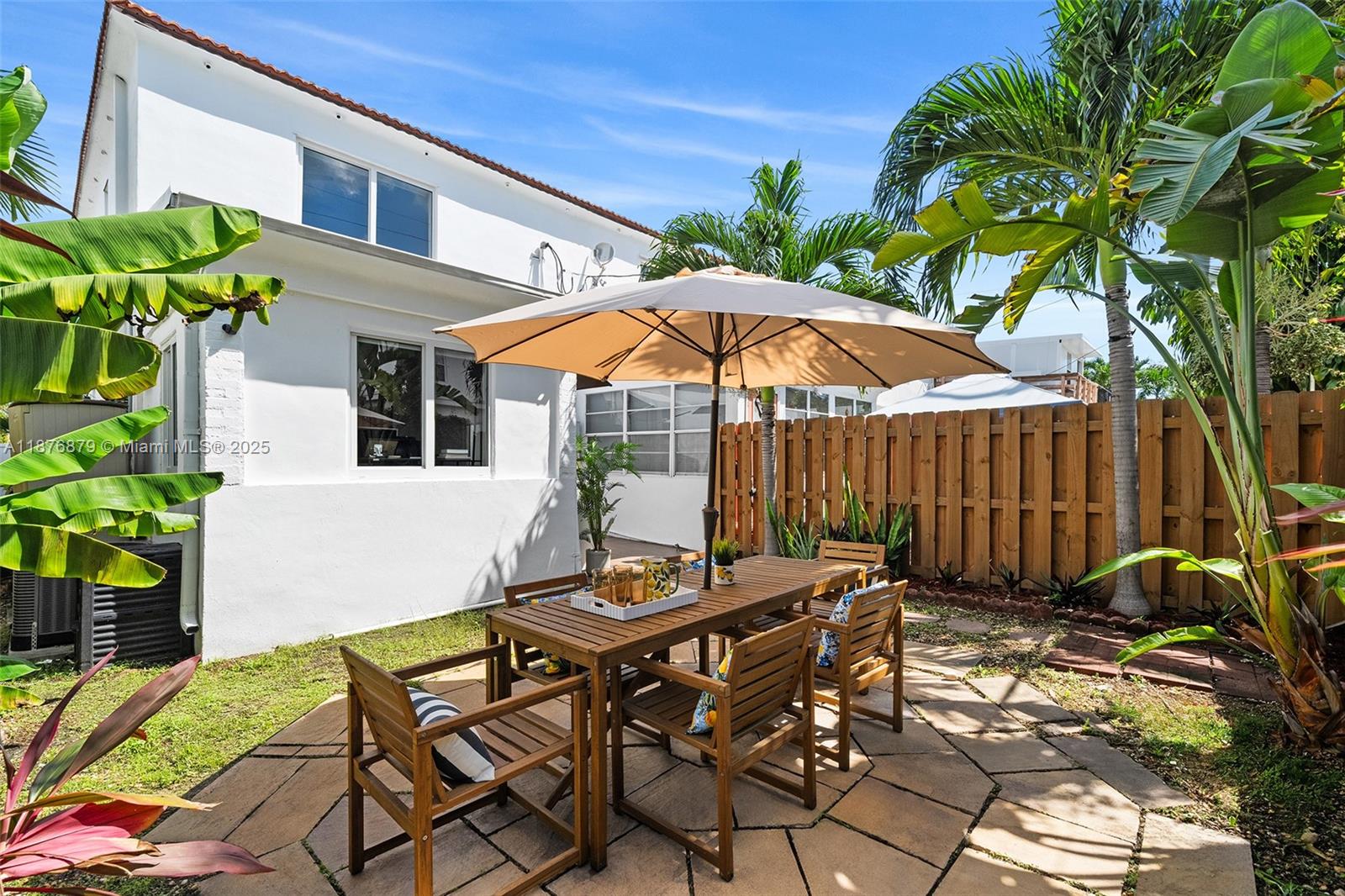 642 86th Street Miami Beach, FL 33141 - Photo 15 of 48 a patio with a table and chairs under an umbrella