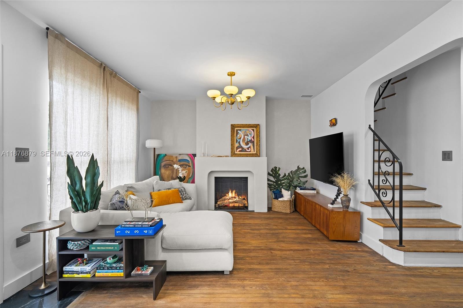 642 86th Street Miami Beach, FL 33141 - Photo 3 of 48 a living room with furniture a fireplace and a flat screen tv