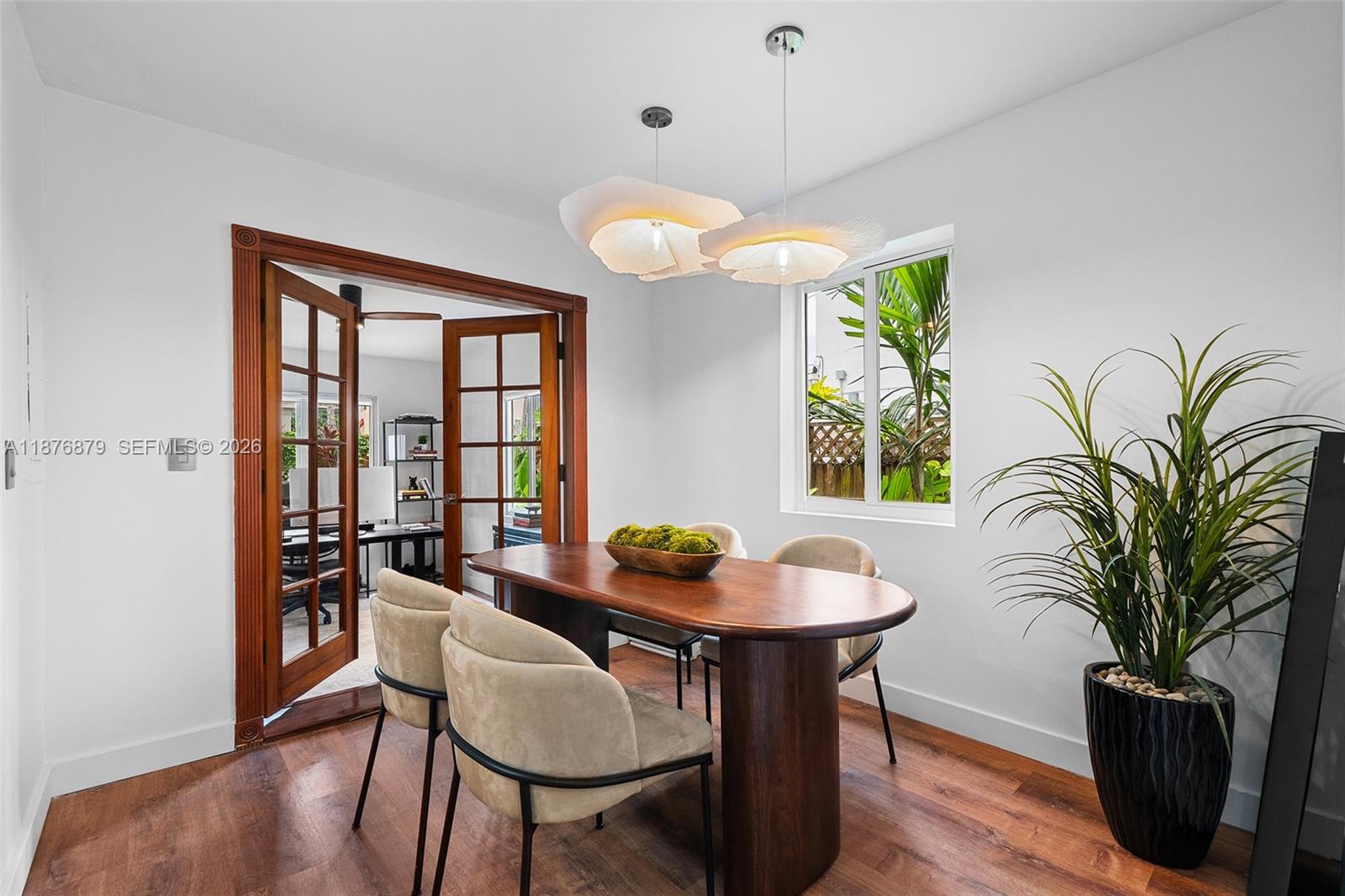 642 86th Street Miami Beach, FL 33141 - Photo 4 of 48 a dining room with furniture potted plants and wooden floor