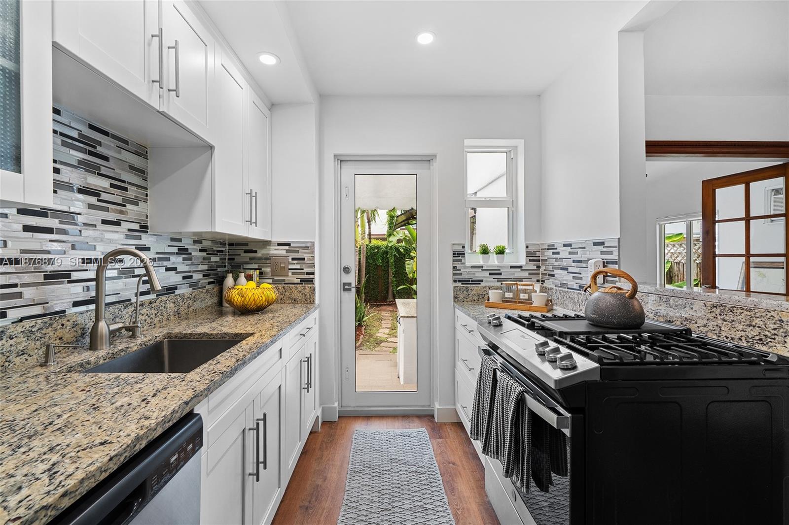 642 86th Street Miami Beach, FL 33141 - Photo 6 of 48 a kitchen with a sink stove and cabinets
