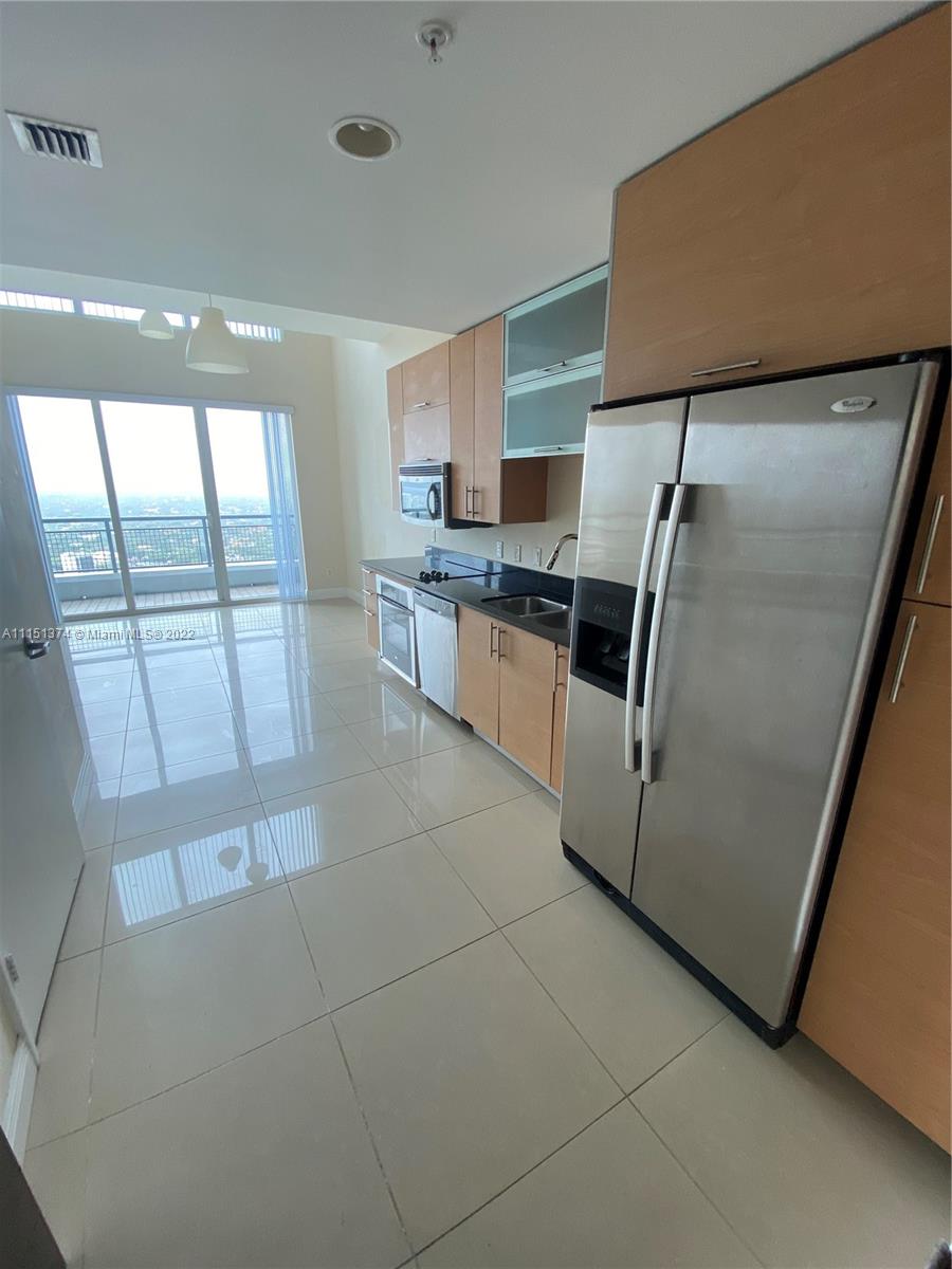 60 Southwest 13th Street, Unit 3003 Miami, FL 33130 - Photo 12 of 22 a kitchen with granite countertop a refrigerator a sink a stove and cabinets