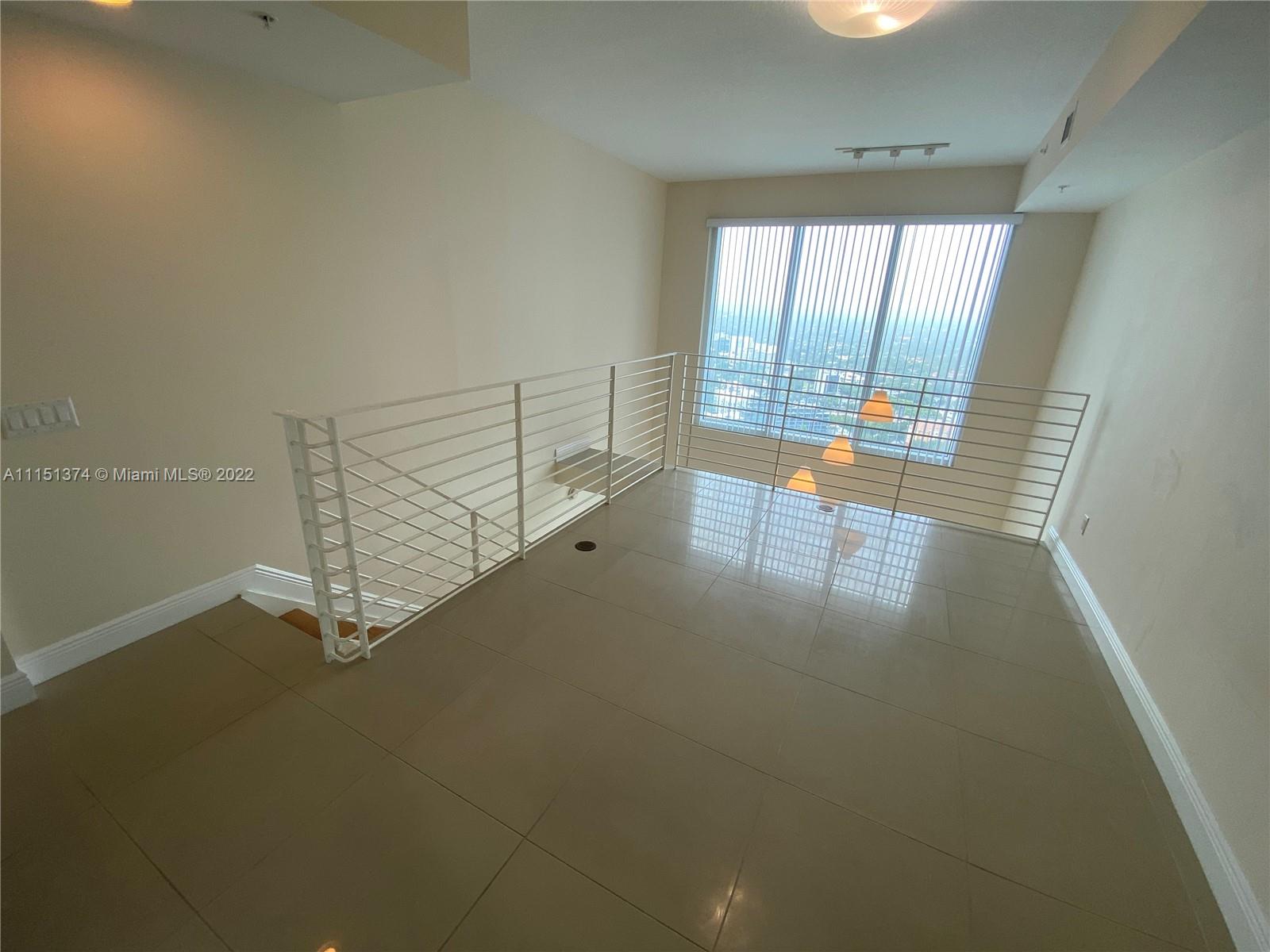 60 Southwest 13th Street, Unit 3003 Miami, FL 33130 - Photo 3 of 22 wooden floor in an empty room with a window