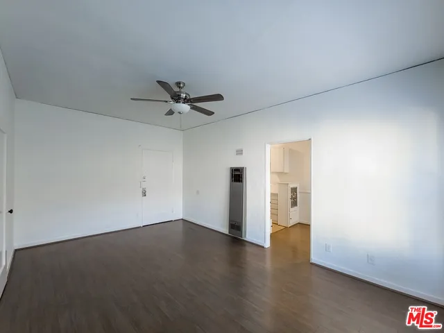 a view of a room with wooden floor and a ceiling fan