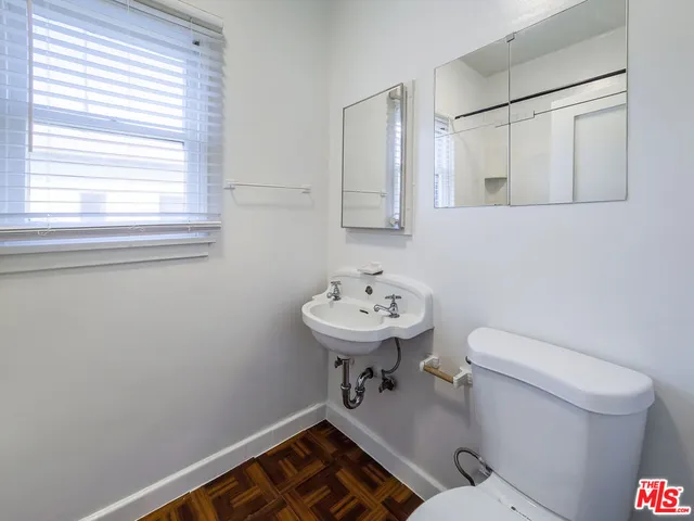 a bathroom with a sink a toilet and a mirror