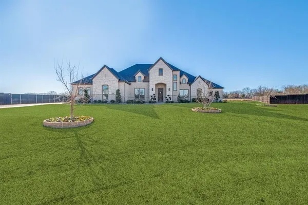 a view of a house with a big yard and large trees