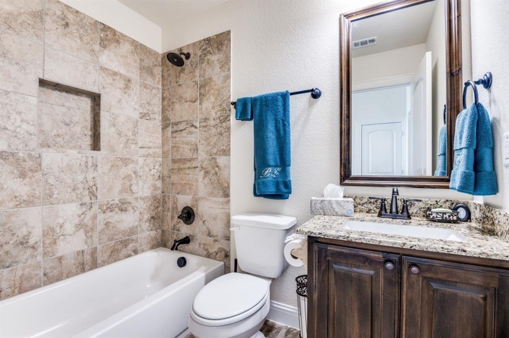8210 Palmer Road Waxahachie, TX 75167 - Photo 15 of 39 a bathroom with a granite countertop toilet sink and bathtub