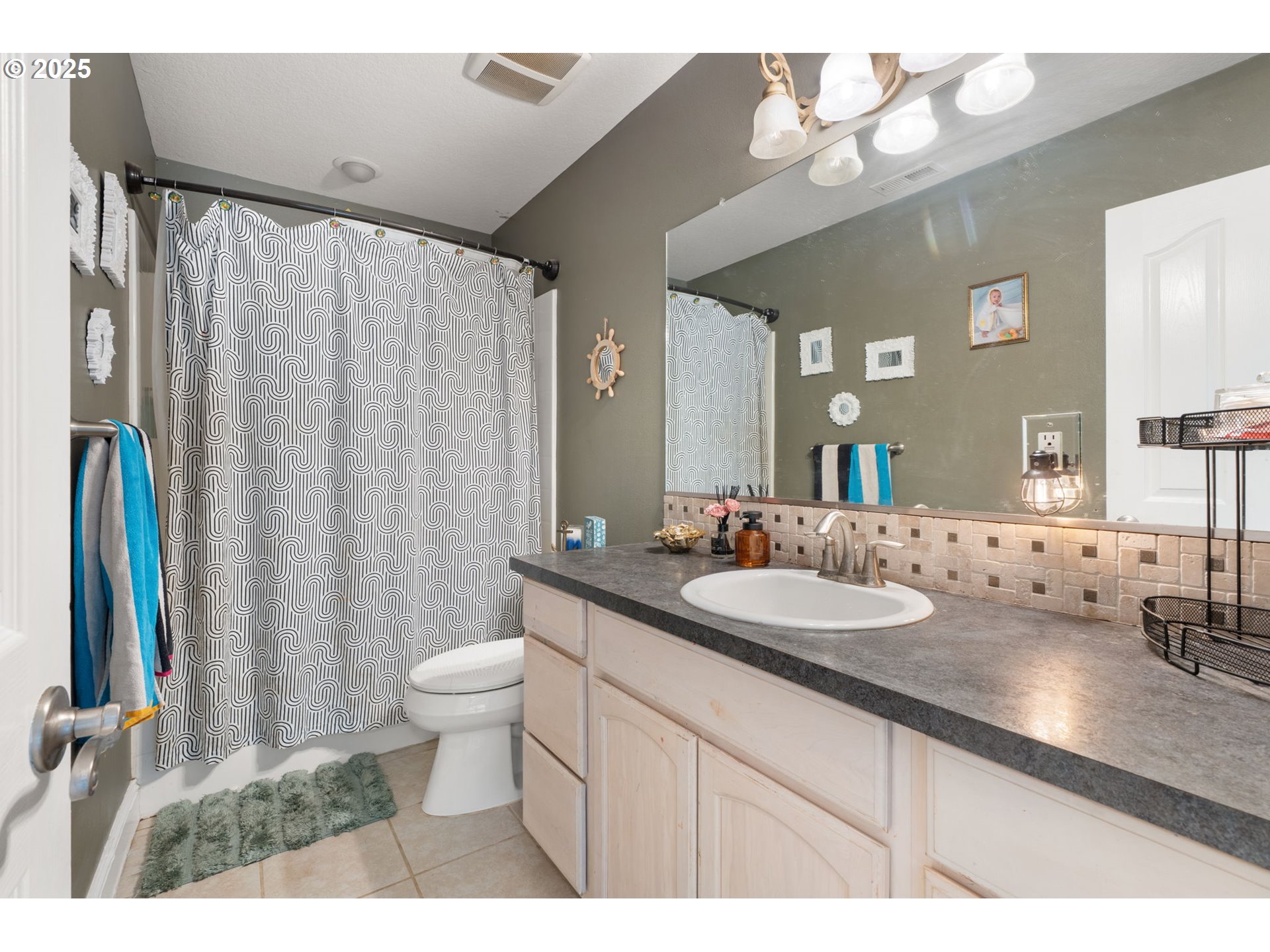 117 Altavista Road Longview, WA 98632 - Photo 28 of 40 a bathroom with a granite countertop sink a toilet a mirror and shower curtain