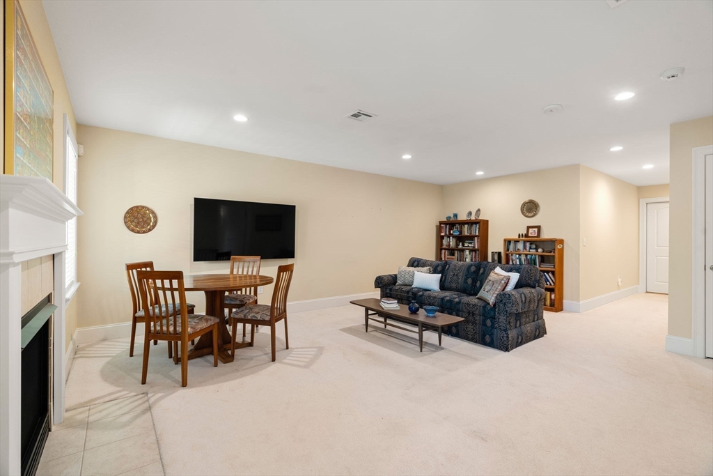 287 Langley Road, Unit 43 Newton, MA 02459 - Photo 29 of 36 a living room with furniture a flat screen tv and a fireplace