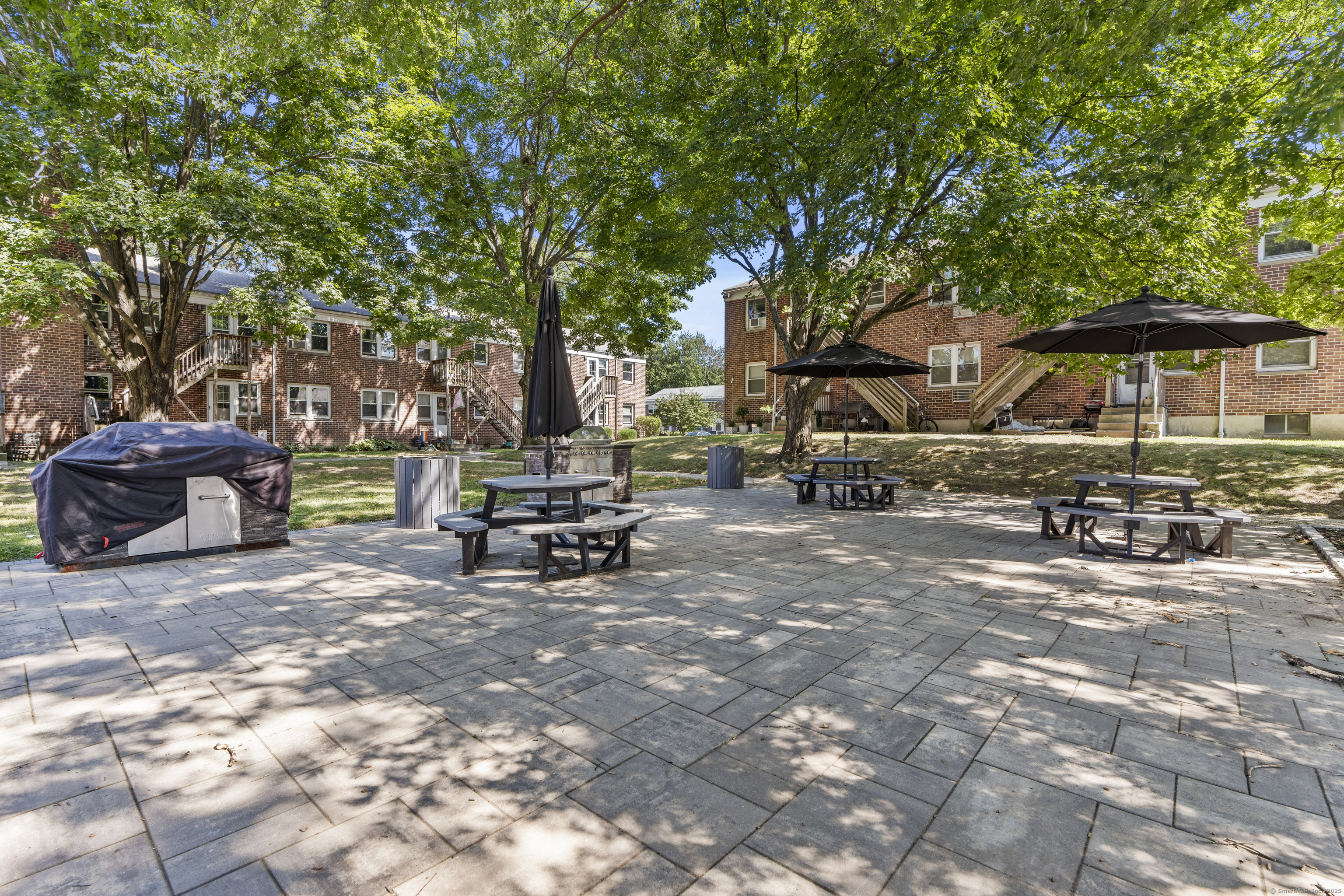 56 Blachley Road, Unit B Stamford, CT 06902 - Photo 16 of 26 a view of backyard with table and chairs under an umbrella