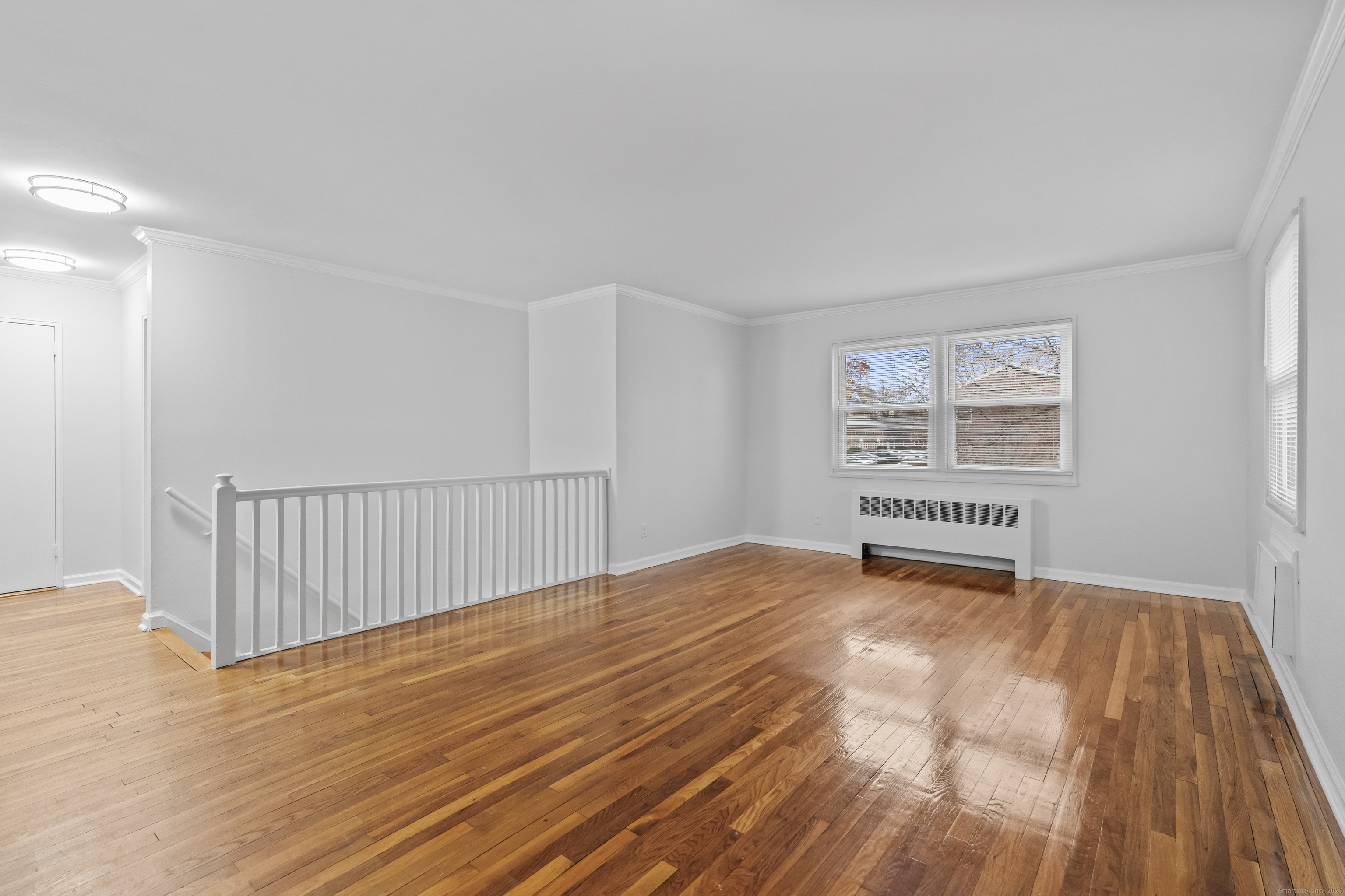 56 Blachley Road, Unit B Stamford, CT 06902 - Photo 5 of 26 a view of an empty room with wooden floor and a window