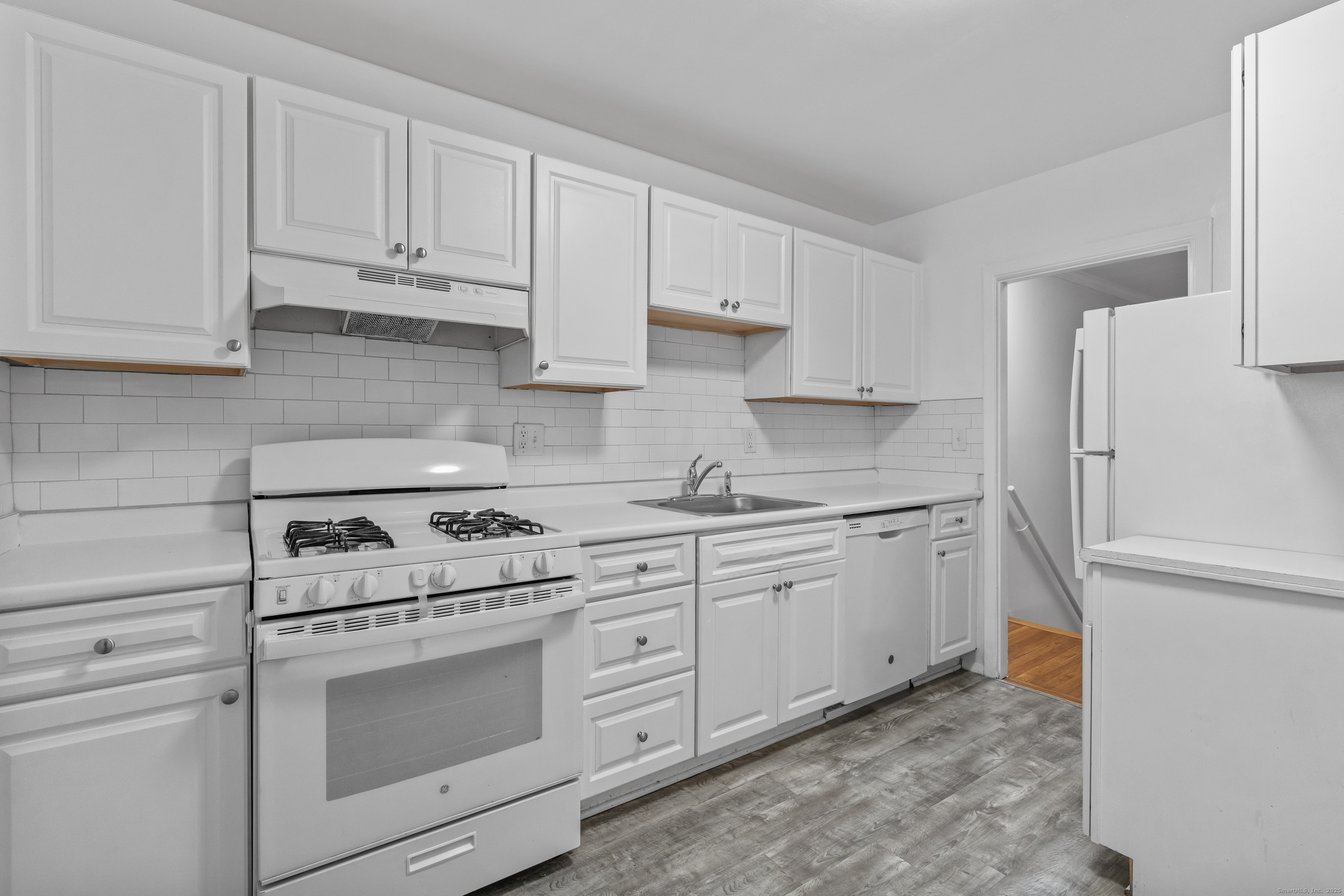56 Blachley Road, Unit B Stamford, CT 06902 - Photo 8 of 26 a kitchen with granite countertop white cabinets and white appliances