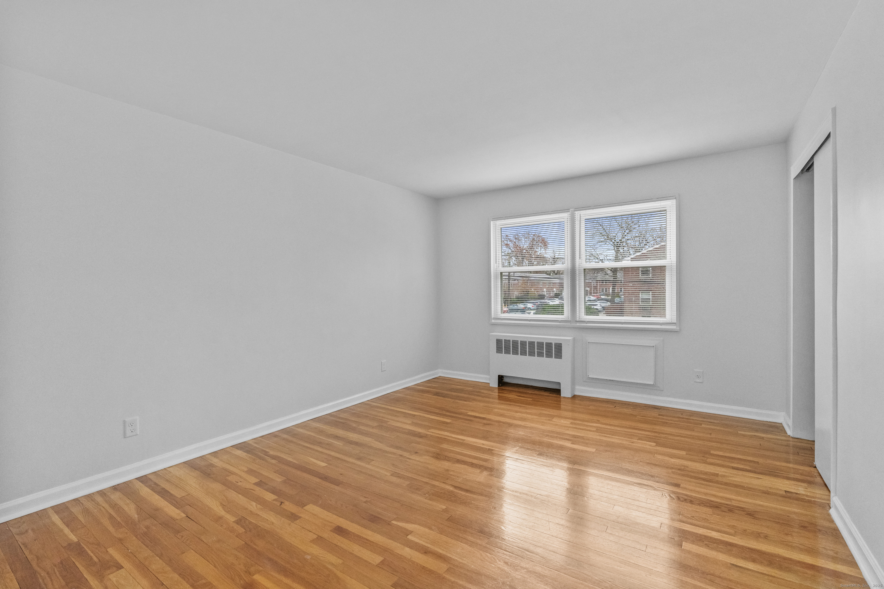 56 Blachley Road, Unit B Stamford, CT 06902 - Photo 10 of 26 a view of an empty room with wooden floor and a window