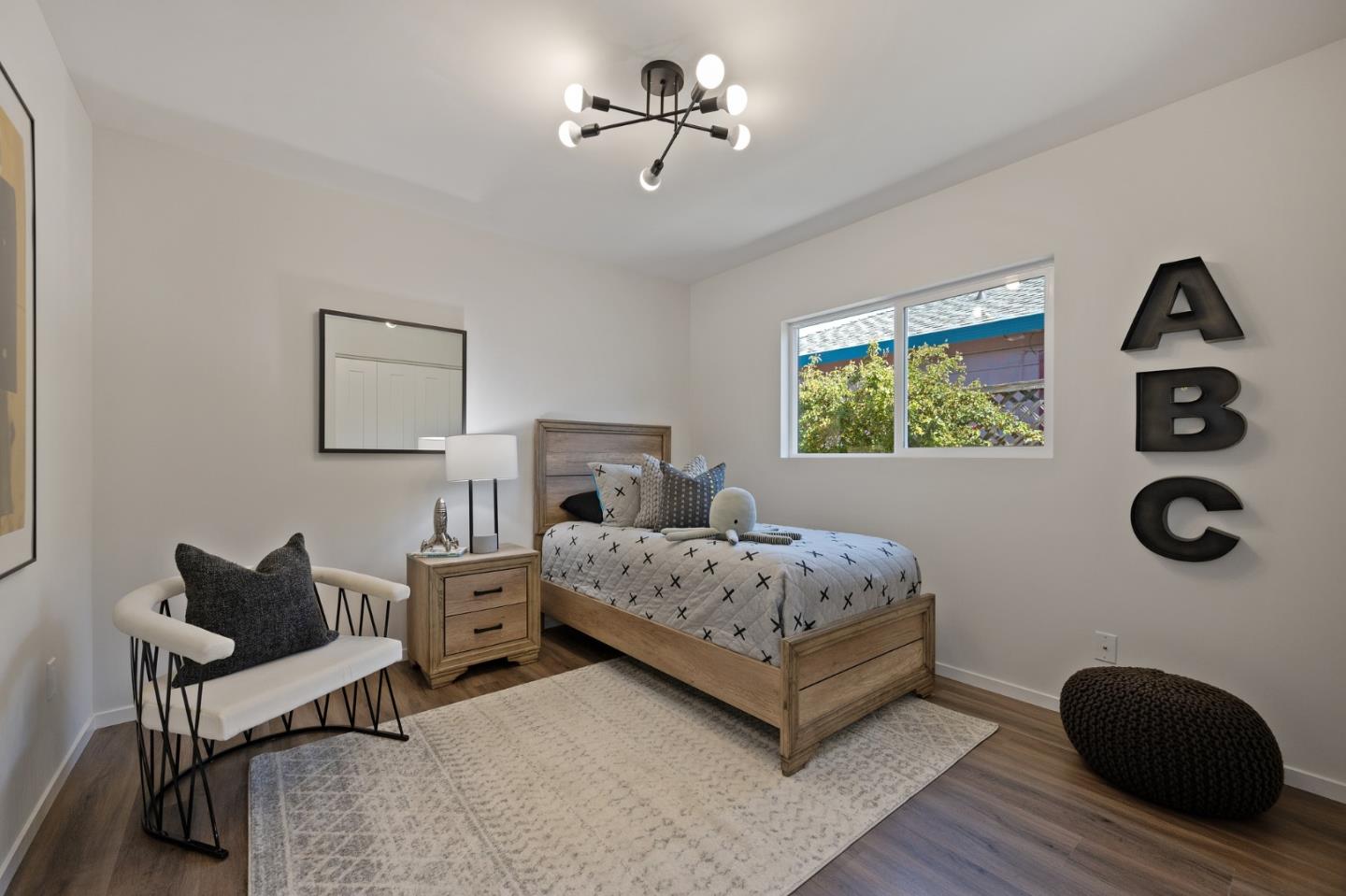 1157 Ruby Street Redwood City, CA 94061 - Photo 20 of 31 a bedroom with a bed and a chandelier
