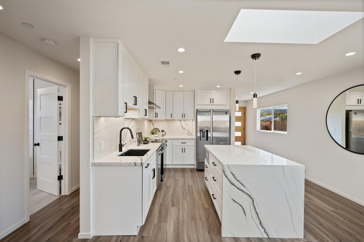 1157 Ruby Street Redwood City, CA 94061 - Photo 7 of 31 a kitchen with stainless steel appliances kitchen island granite countertop a stove and a refrigerator